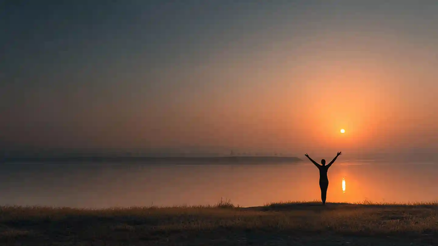 Person performing Surya Namaskar with sunrise in the background – Surya Namaskar Mantra